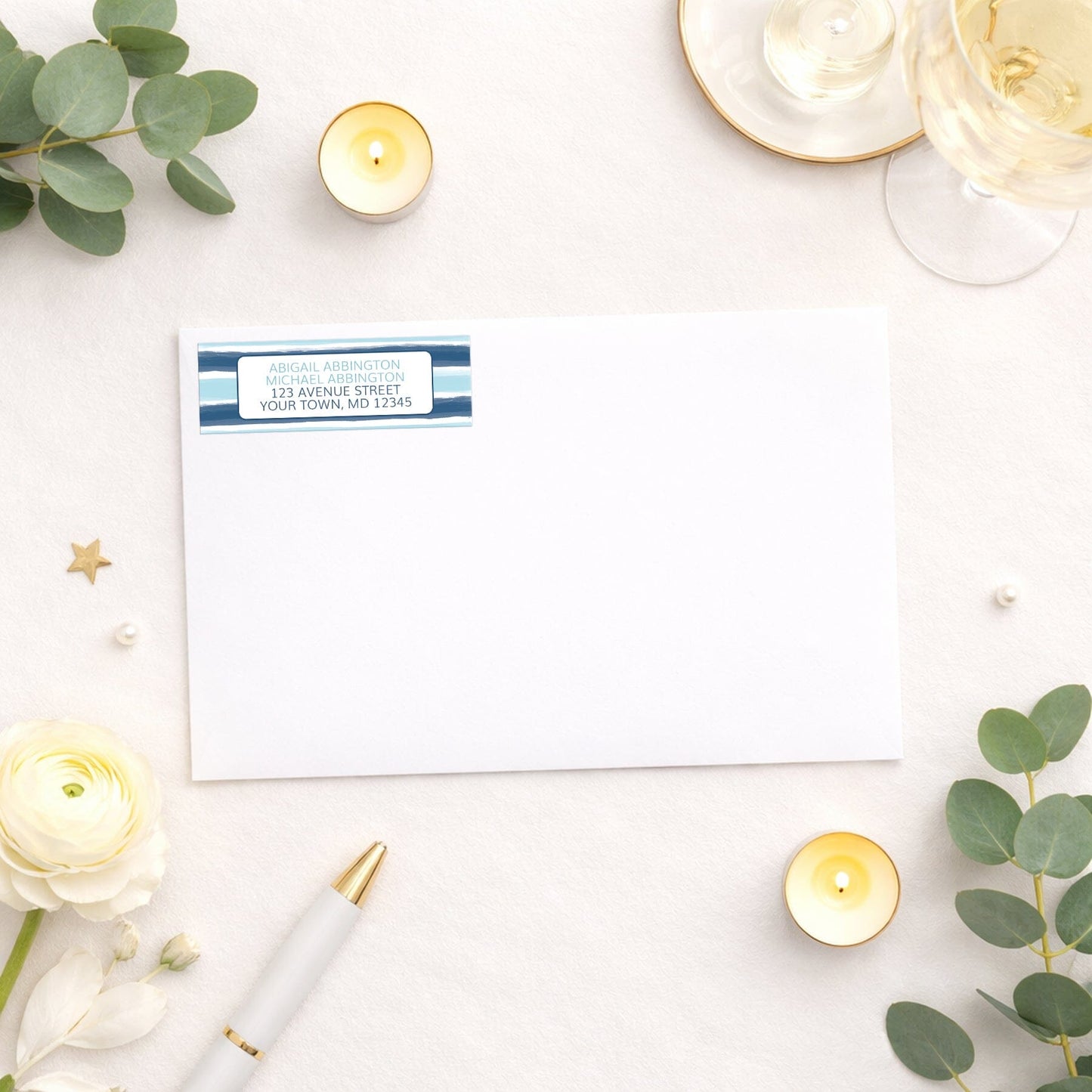 Coastal Paint Brush Strokes Address Label shown on white envelope with wedding and shower supplies.
