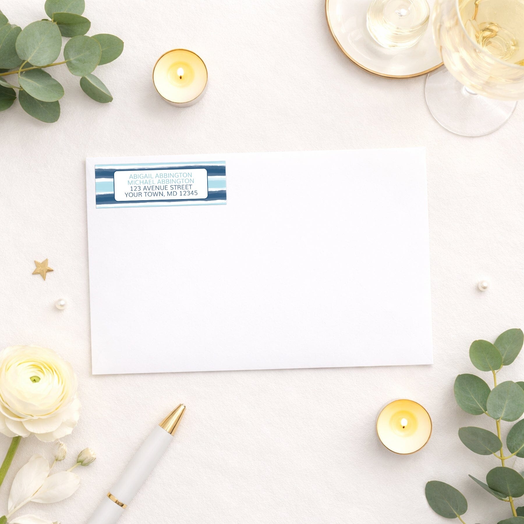 Coastal Paint Brush Strokes Address Label shown on white envelope with wedding and shower supplies.
