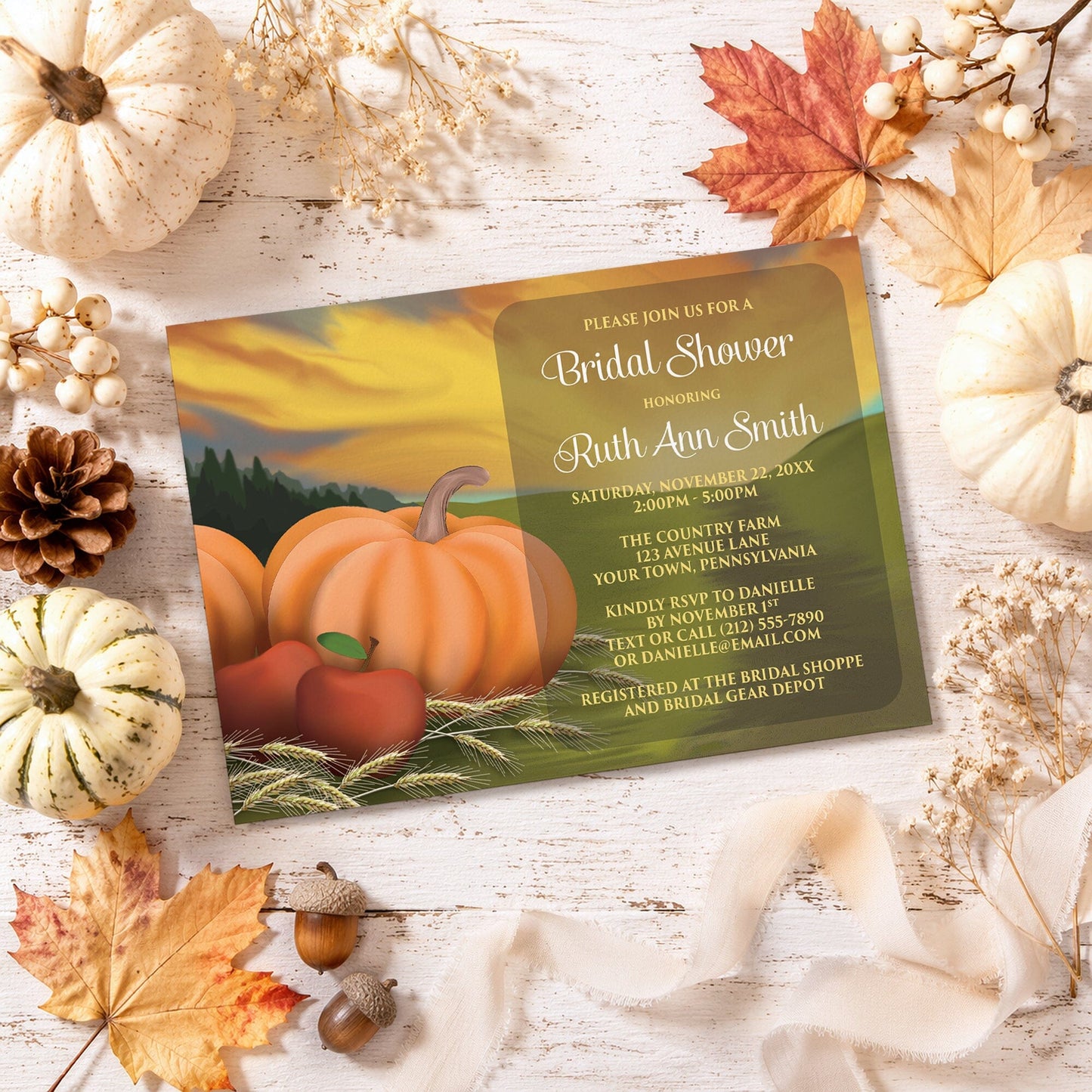 Country Autumn Harvest Bridal Shower Invitation with pumpkins and apples shown on a wooden surface with fall decorations.