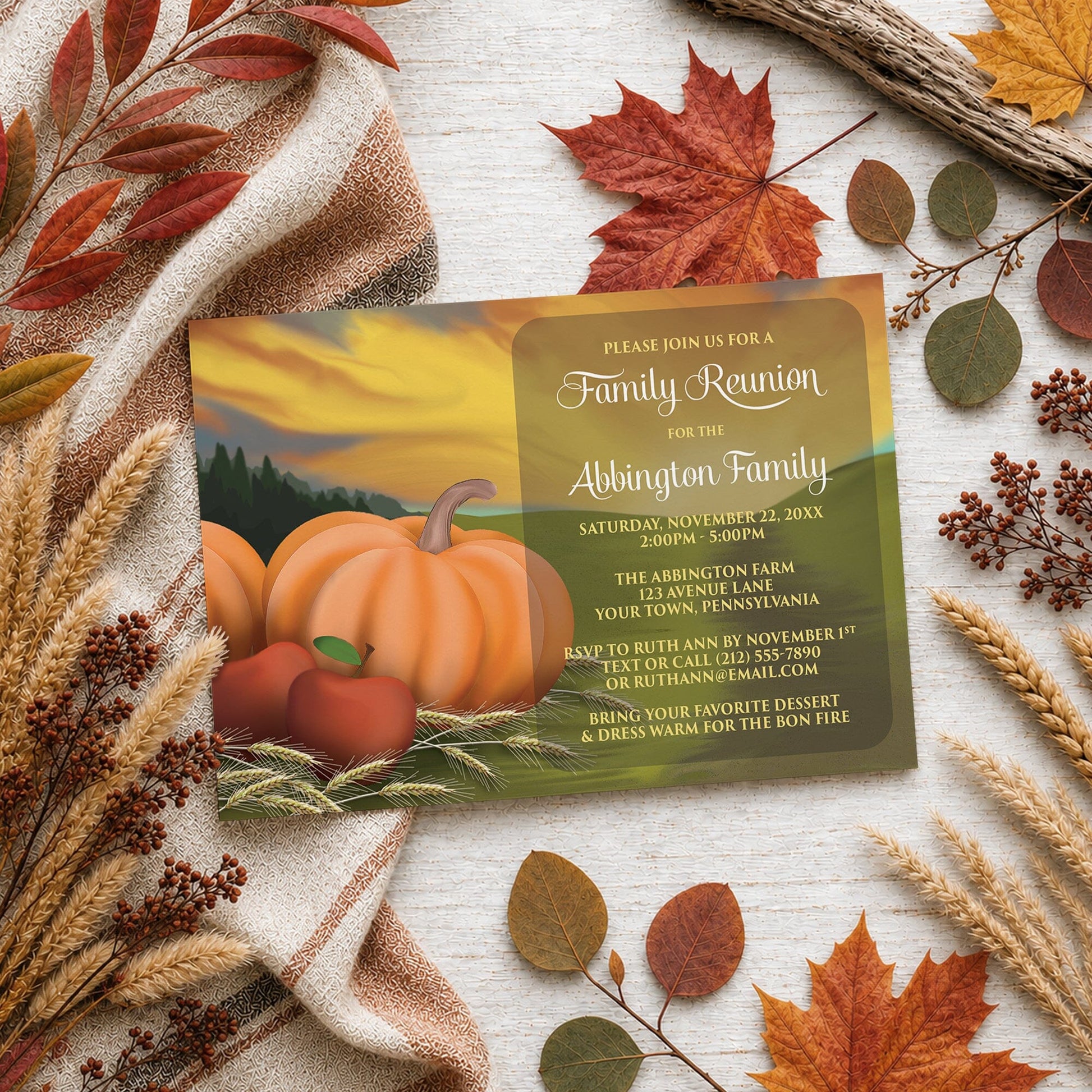 Country Autumn Harvest Family Reunion Invitation shown on a wooden surface with fall leaves and autumn decor.