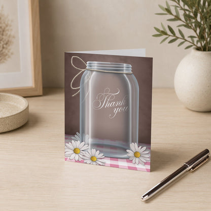 Country Mason Jar Daisy Gingham Thank You Card on a desk with a vase and a pen.