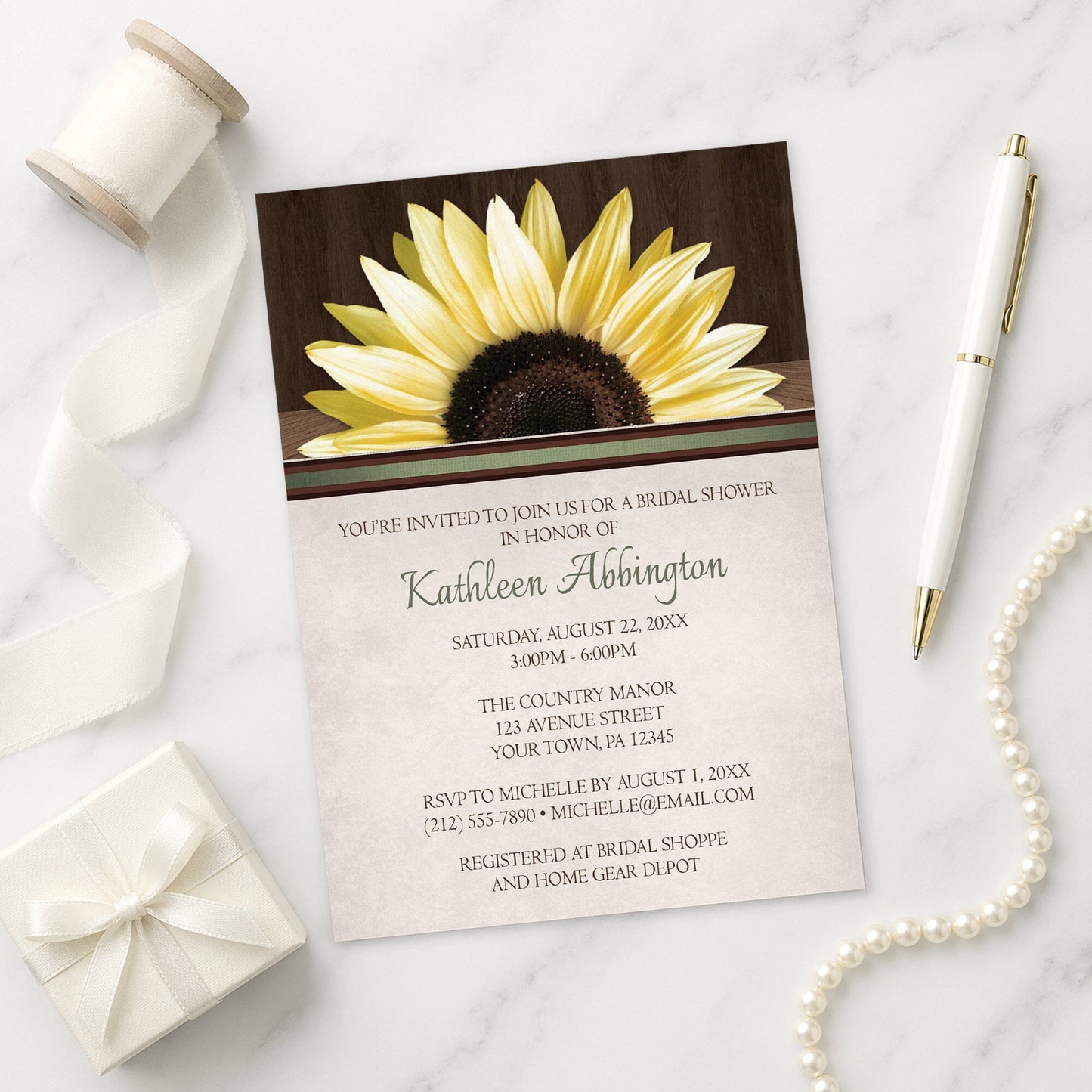 Country Sunflower Over Wood Rustic Bridal Shower Invitation shown on a marble surface with a white gift box, pen, ribbon, and pearls.