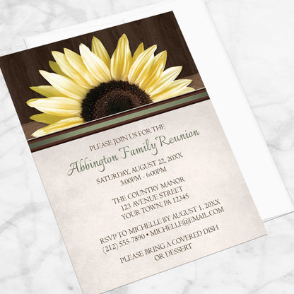 Country Sunflower Over Wood Rustic Family Reunion Invitation shown at an angle on a marble surface with a white envelope.