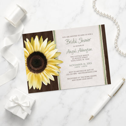 Sunflower-themed bridal shower invitation on a marble surface with decorative items.
