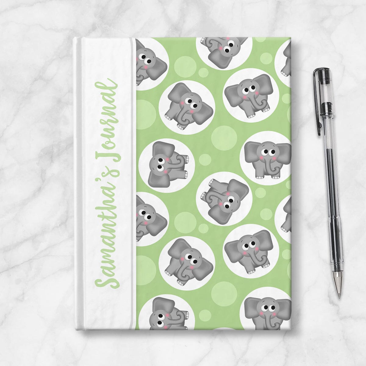 Personalized Cute Green Elephant Journal at Artistically Invited. Image shows the book on a countertop next to a pen.