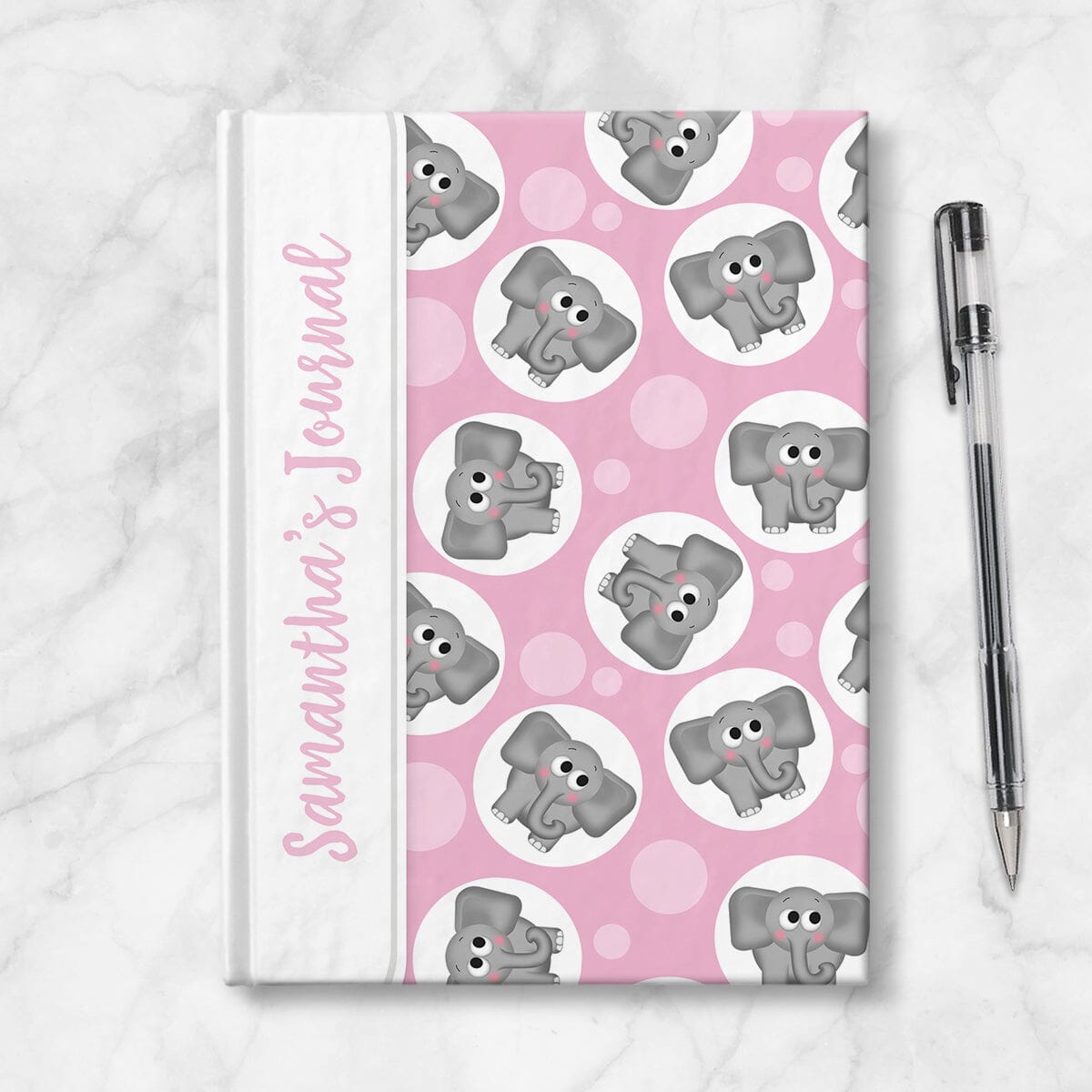 Personalized Cute Pink Elephant Journal at Artistically Invited. Image shows book on countertop with a pen next to it. 