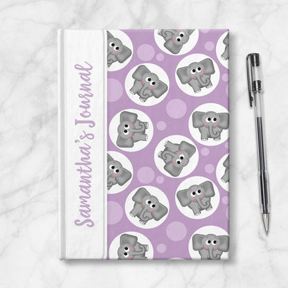 Personalized Cute Purple Elephant Journal at Artistically Invited. Image shows the book on a countertop next to a pen.