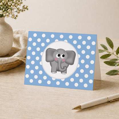 Cute Elephant Blue Polka Dot Note Card shown on a desk with a vase, plants, and a pen.