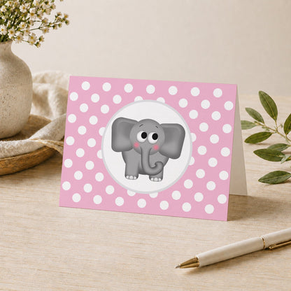 Cute Elephant Pink Polka Dot Note Card shown on a desk with a vase, plants, and a pen.