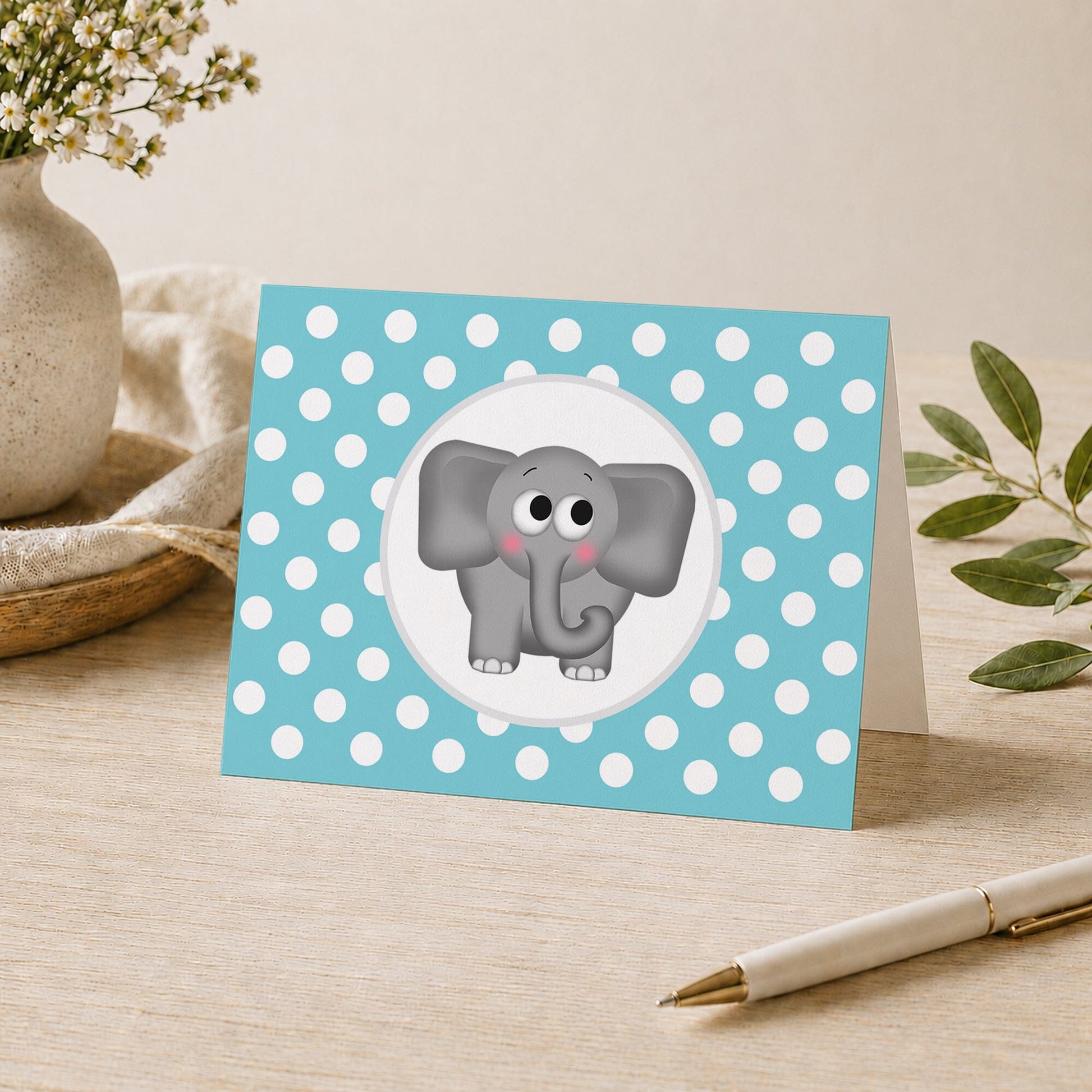 Cute Elephant Turquoise Polka Dot Note Card shown on a desk with a vase, plants, and a pen.