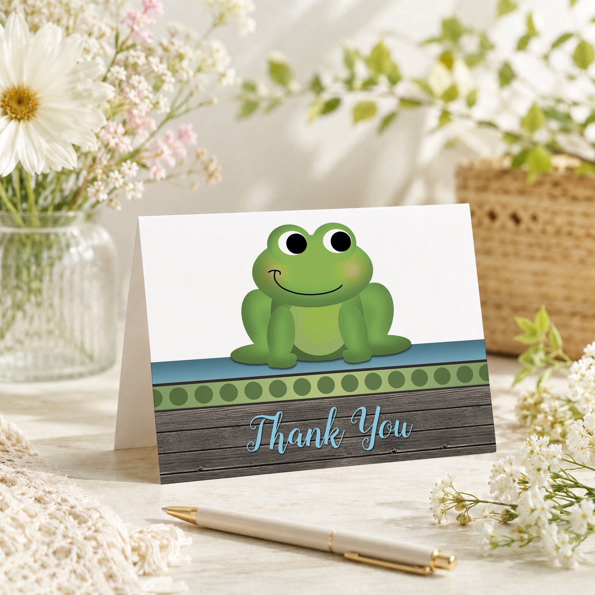 Cute Frog Green Rustic Wood Thank You Card shown on a tabletop with a vase, spring and summer flowers, and a pen.