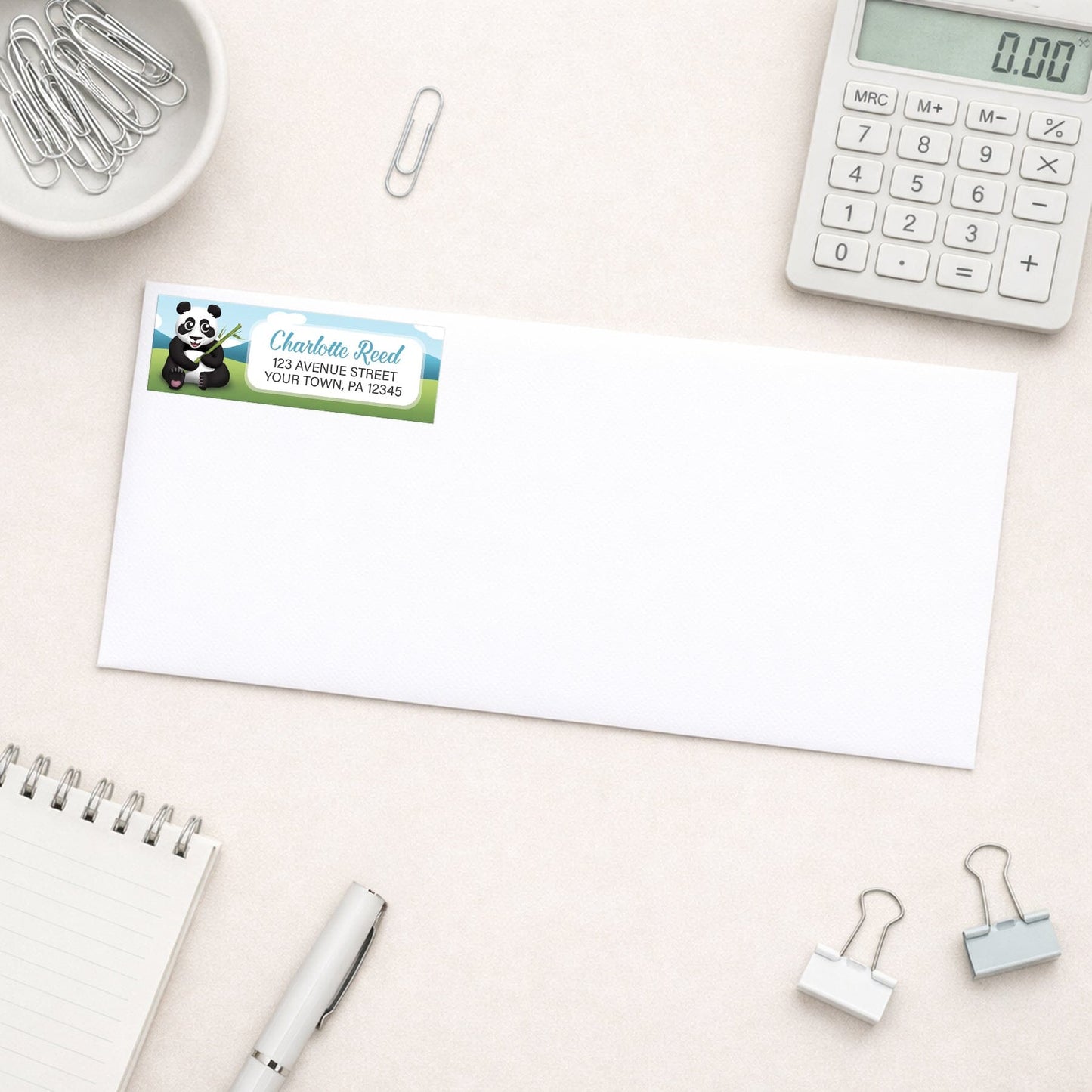 Cute Panda with Bamboo Address Label shown on a white envelope with everyday office supplies