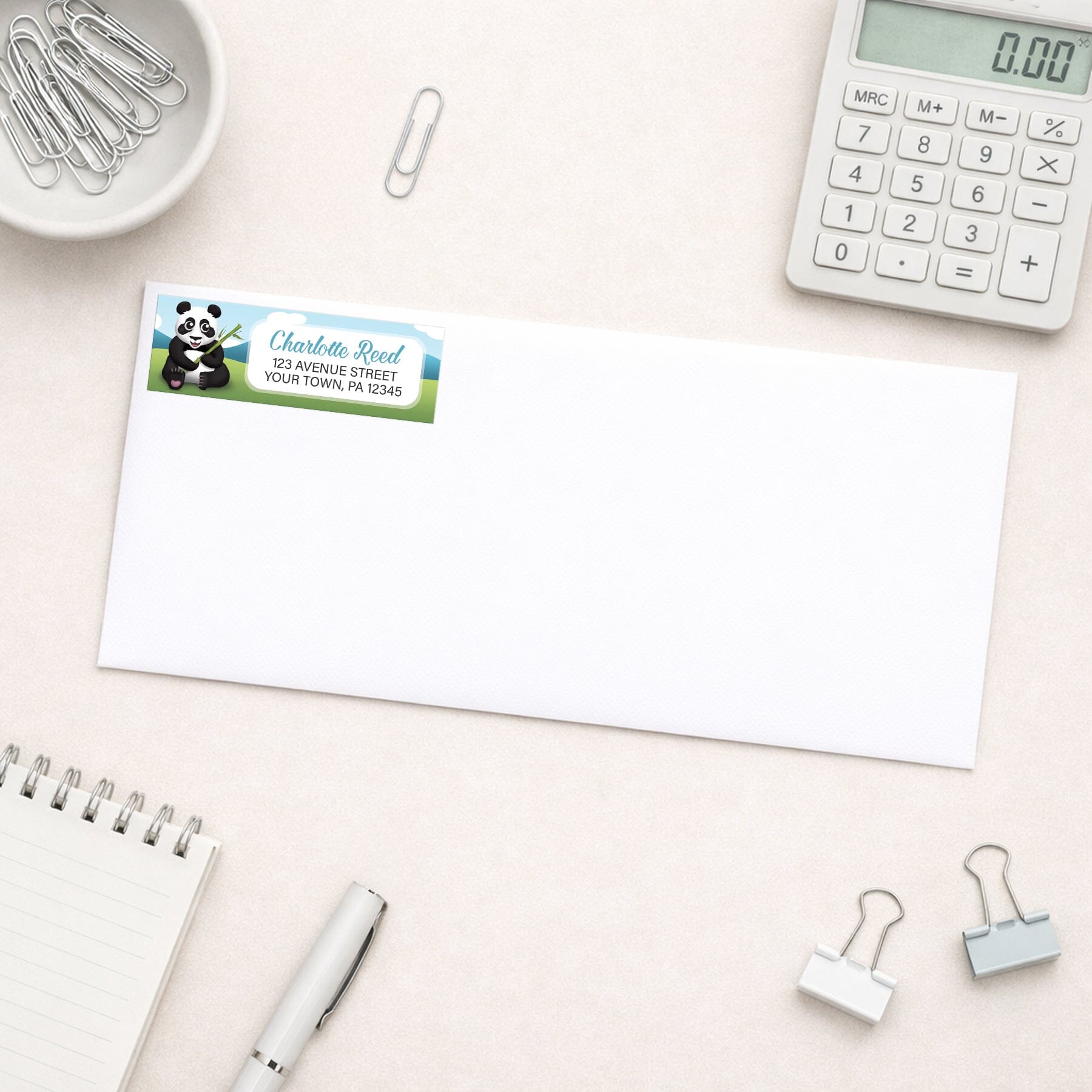 Cute Panda with Bamboo Address Label shown on a white envelope with everyday office supplies