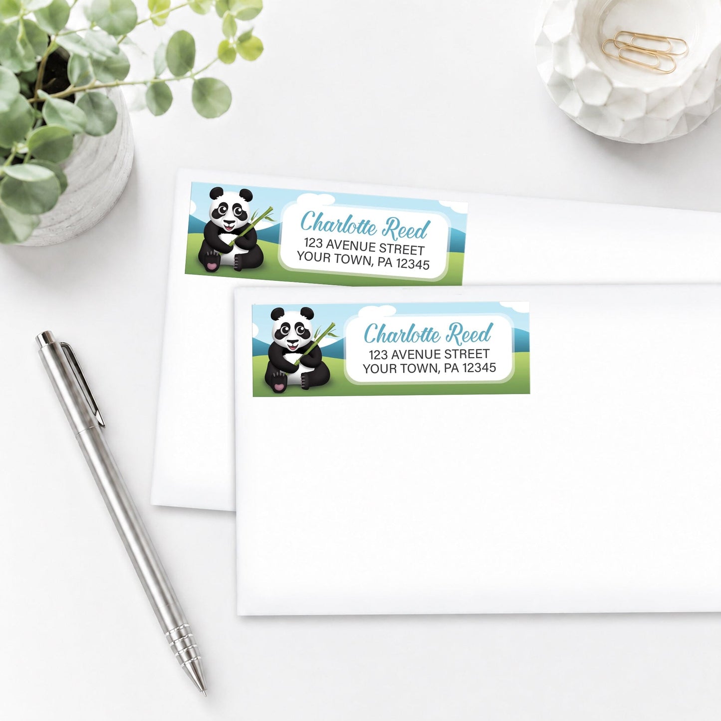 Cute Panda with Bamboo Address Labels, shown on white envelopes, on a white surface with a pen and plant.
