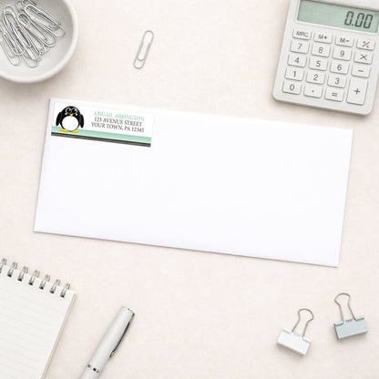 Cute Penguin Mint Green Rustic Address Label shown on a white envelope with everyday office supplies