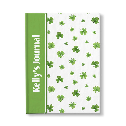 Personalized Dainty Shamrocks and Clovers Journal at Artistically Invited. A custom book with a green color wrapping around the spine area to complement the dainty shamrocks and clovers pattern, small and minimal over white, on the rest of the cover. Your personalized name is custom printed sideways in white over the green color area near the spine.