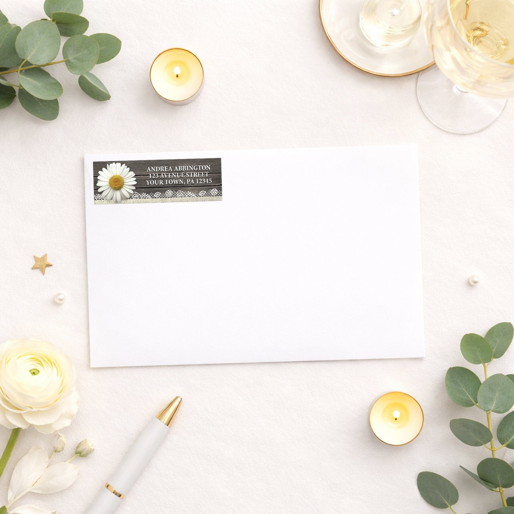 Daisy Burlap and Lace Wood Address Label shown on a white envelope with wedding and shower supplies