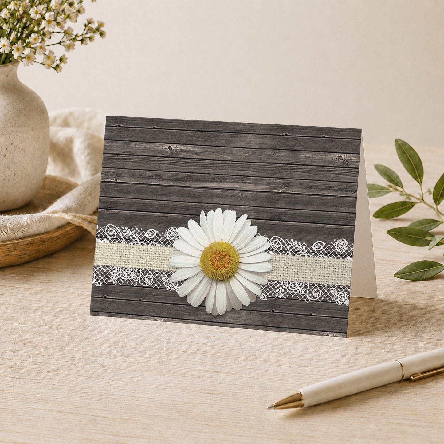 Daisy Burlap and Lace Wood Note Card shown on a desk with a vase, plants, and a pen.