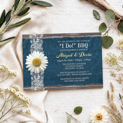 Daisy Denim and Lace I Do BBQ Couples Shower Invitation shown on a light wooden surface with spring and summer plants.