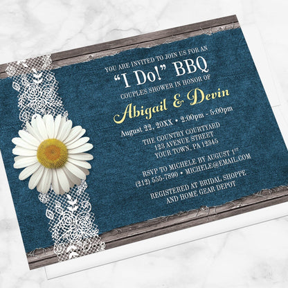 Daisy Denim and Lace I Do BBQ Couples Shower Invitation shown at an angle on a marble surface with a white envelope.