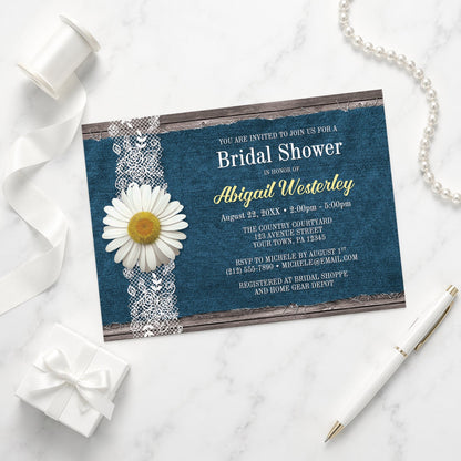 Daisy Denim and Lace Rustic Bridal Shower Invitation shown on a marble surface with a white gift box, pen, ribbon, and pearls.