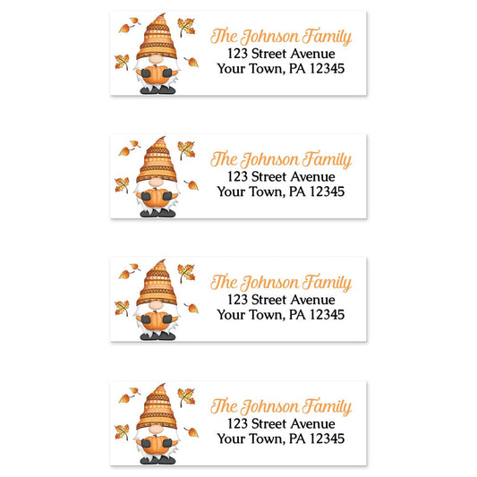 Fall Pumpkin Gnome Address Labels at Artistically Invited. Sheet of 4 labels. These address labels are designed with an illustration of a cute gnome holding an orange pumpkin with autumn leaves around him. Your personalized return address is custom printed in orange and black over white to the right of the autumn-themed gnome.