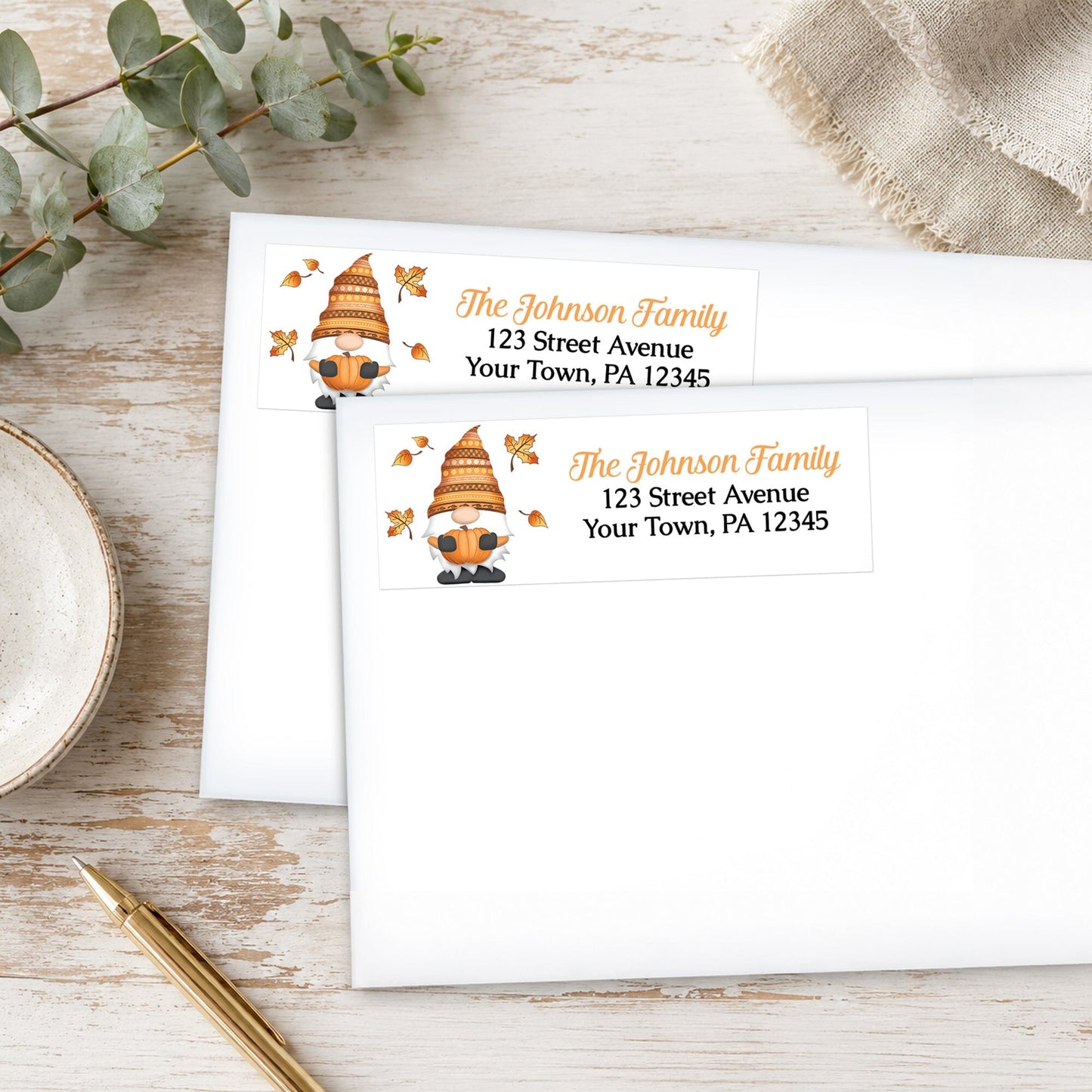 Fall Pumpkin Gnome Address Labels on white envelopes, shown on a wooden surface with plants and a pen.