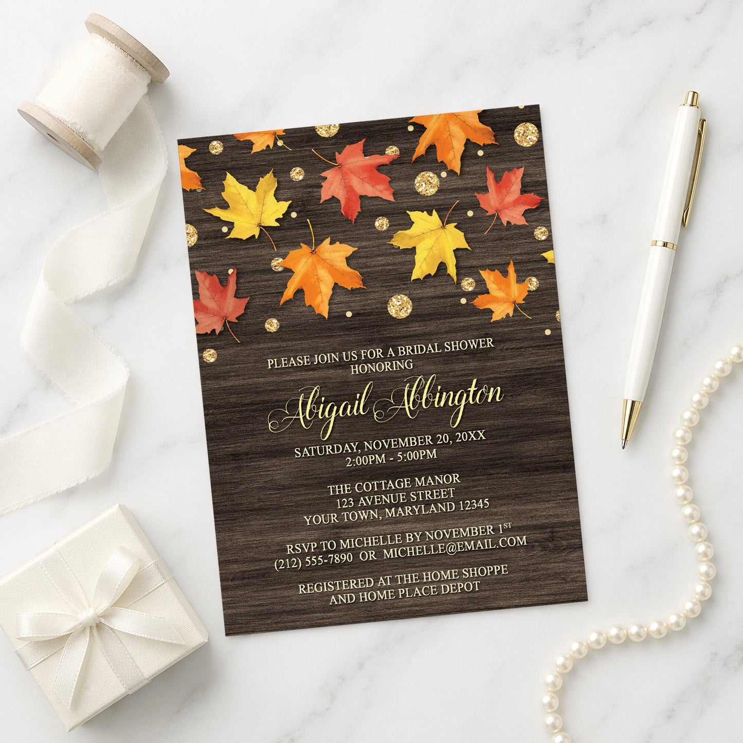 Falling Leaves with Gold Autumn Bridal Shower Invitation shown with decorative elements on a marble surface.