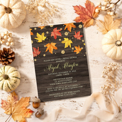 Falling Leaves with Gold Autumn Bridal Shower Invitation shown with leaves and pumpkins on a wooden surface