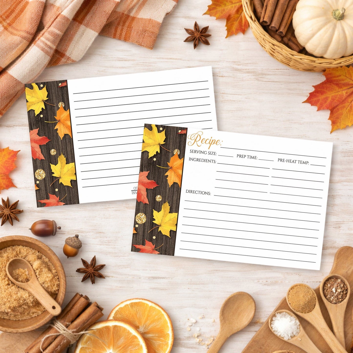 Set of Falling Leaves with Gold Autumn Recipe Cards on a wooden surface with fall-themed decor and kitchen ingredients.