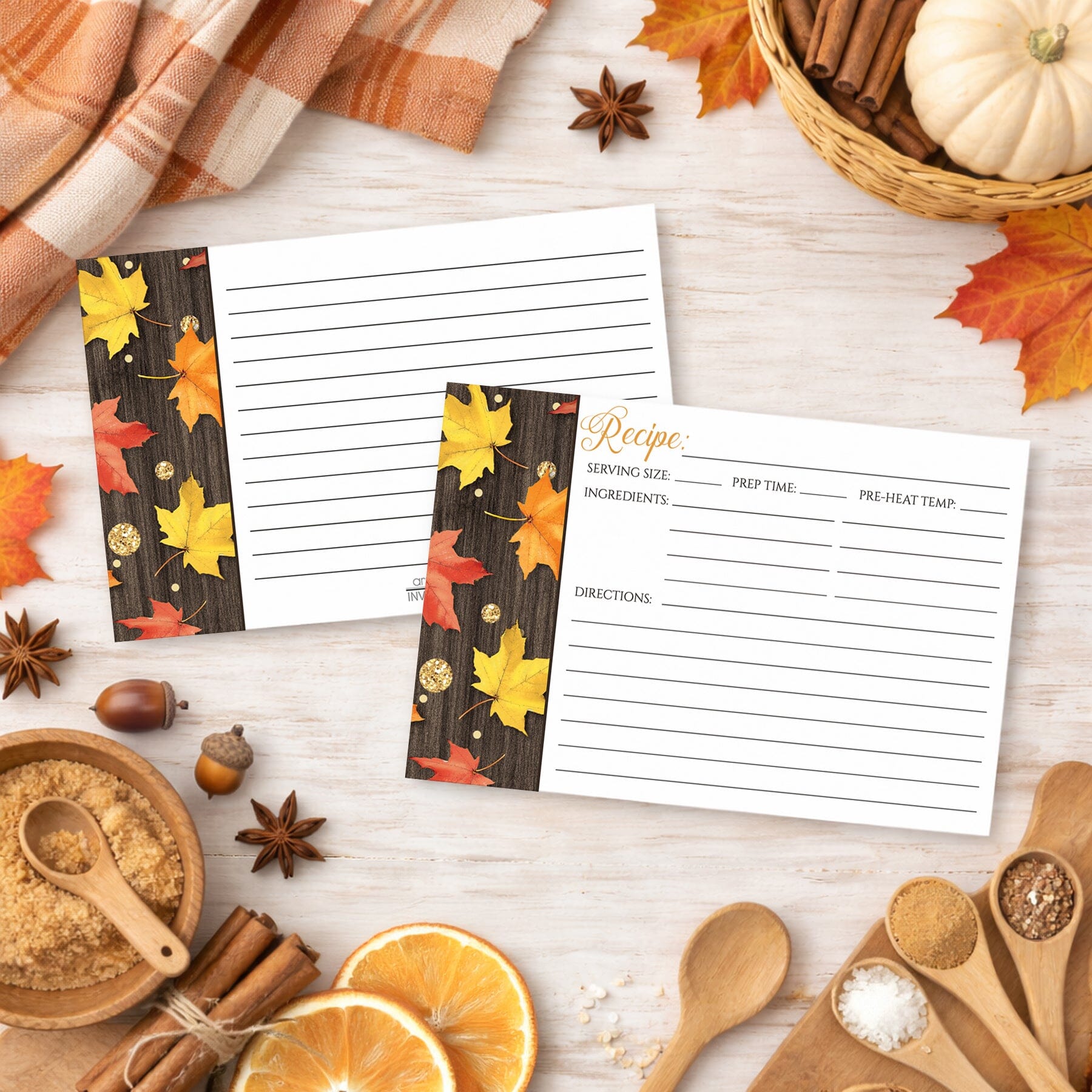 Set of Falling Leaves with Gold Autumn Recipe Cards on a wooden surface with fall-themed decor and kitchen ingredients.