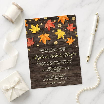 Falling Leaves with Gold Autumn Vow Renewal Invitation on a marble surface with a white gift box, pen, ribbon, and pearls.