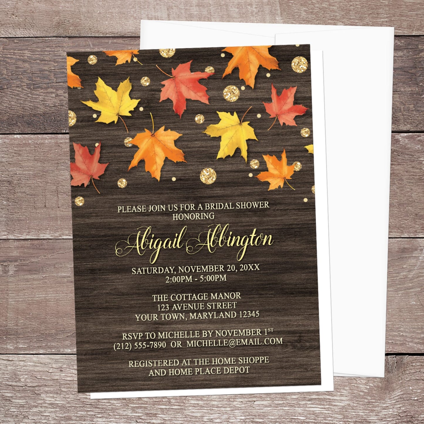 Autumn-themed bridal shower invitation with leaves on a wooden background shown with a white envelope