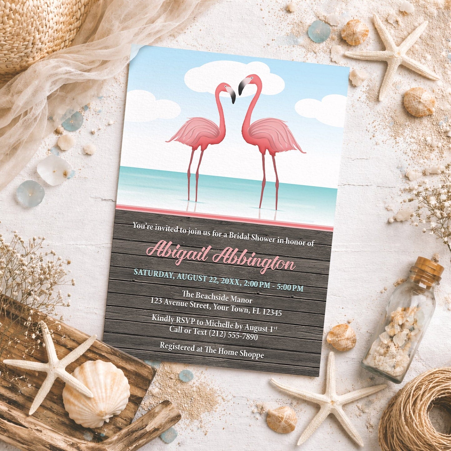 Flamingos in the Water Rustic Bridal Shower Invitation on a beach-themed background with seashells and other beach decor.