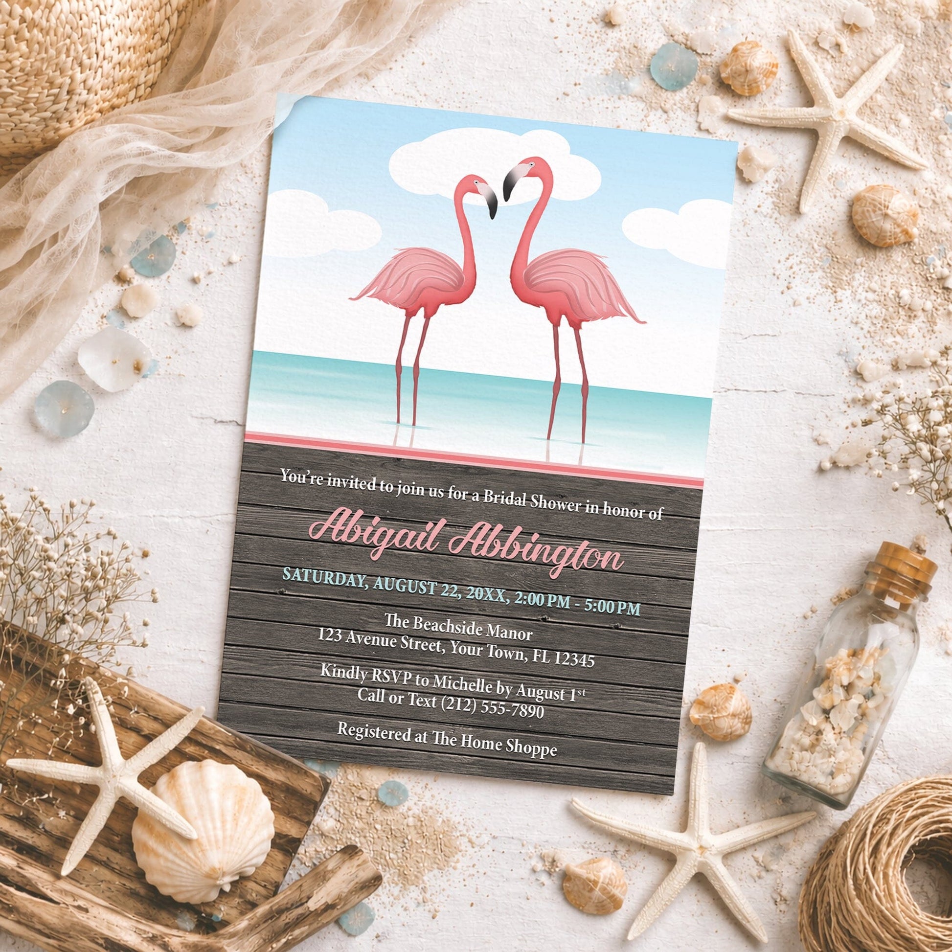 Flamingos in the Water Rustic Bridal Shower Invitation on a beach-themed background with seashells and other beach decor.