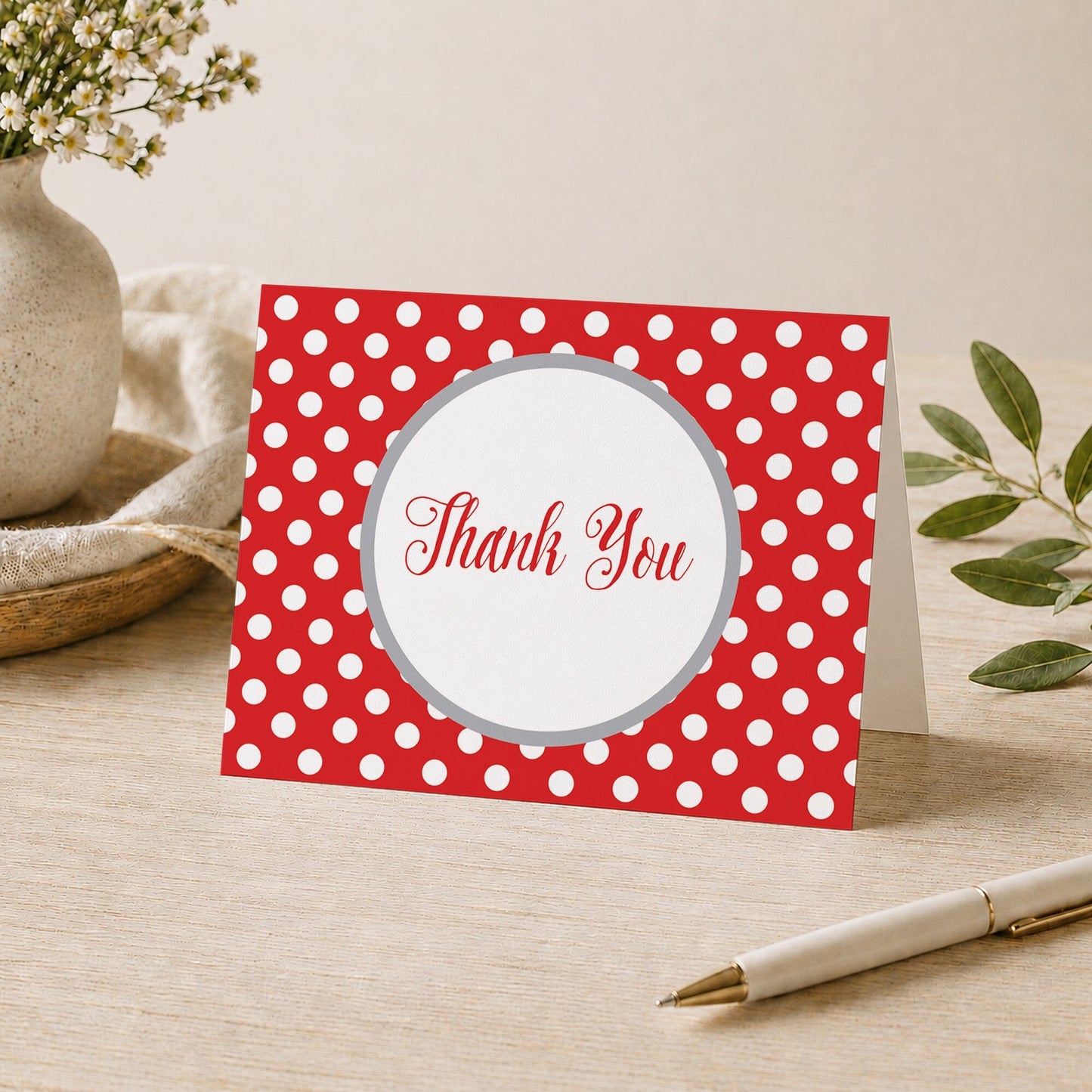 Gray and Red Polka Dot Thank You Card shown on a desk with a vase, plants, and a pen.