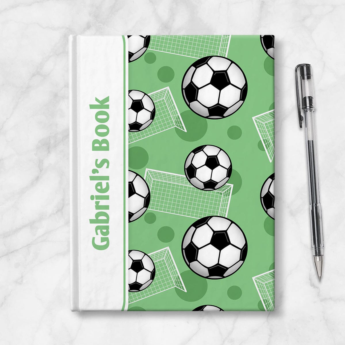 Personalized Green Soccer Journal at Artistically Invited. Image shows the book on a countertop with a pen next to it.