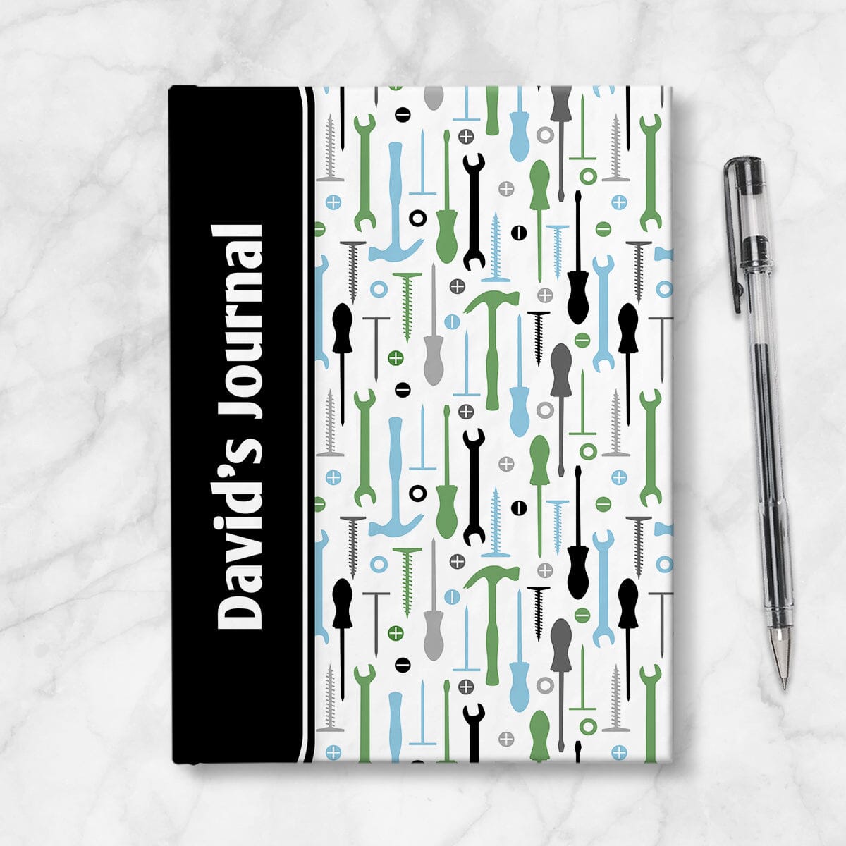 Personalized Green Blue Tools Pattern Journal at Artistically Invited. A custom book designed with a black color block wrapping around the spine area over an organized pattern of green, blue, black, and gray tools on the rest of the background. This handyman or contractor-inspired pattern includes hammers, screwdrivers, wrenches, nails, screws, and washers. Your personalized name and text of your choice is custom printed sideways in white over the black color block on the front near the spine.
