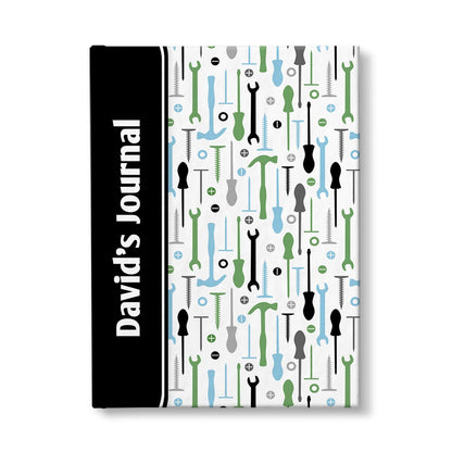 Personalized Green Blue Tools Pattern Journal at Artistically Invited. A custom book designed with a black color block wrapping around the spine area over an organized pattern of green, blue, black, and gray tools on the rest of the background. This handyman or contractor-inspired pattern includes hammers, screwdrivers, wrenches, nails, screws, and washers. Your personalized name and text of your choice is custom printed sideways in white over the black color block on the front near the spine.