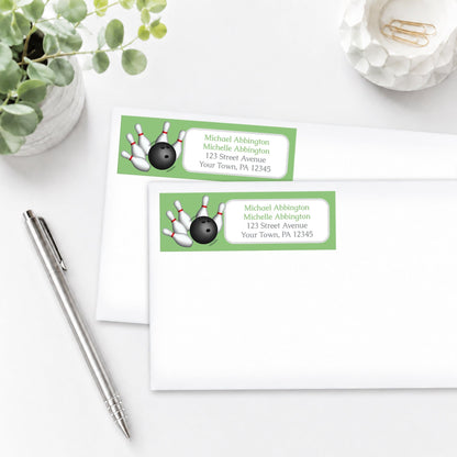 Green Bowling Address Labels on white envelopes, shown on a white surface with a plant and a pen.