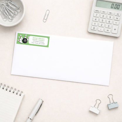 Green Bowling Return Address Label shown on a white envelope with everyday office supplies