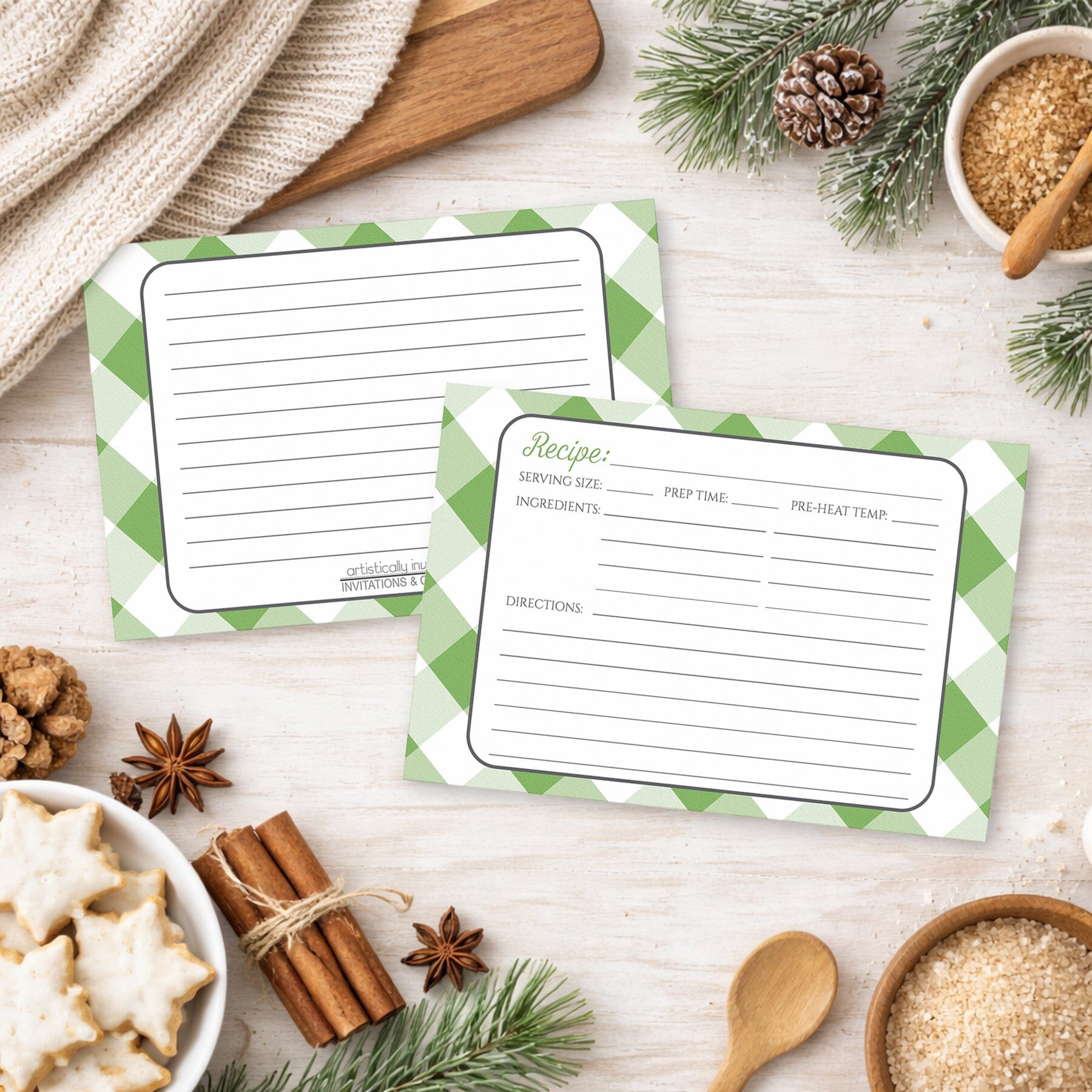 Two Green Gingham Recipe Cards on a wooden surface with winter and holiday decorations, cookies, and ingredients.