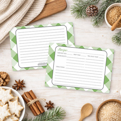 Two Green Gingham Recipe Cards on a wooden surface with winter and holiday decorations, cookies, and ingredients.