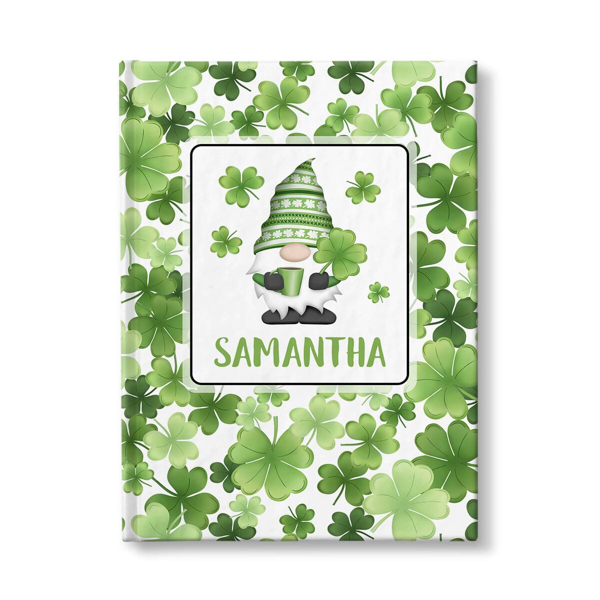 Personalized Green Shamrocks Gnome Journal at Artistically Invited. A custom book designed with an adorable gnome holding a hot beverage and a 4-leaf clover with 4 shamrocks floating around him in a white rectangular design on the front of the book, with your name personalized in green in a cute all capital letters font below the gnome. The background design that wraps around the cover of the book features a beautiful pattern of shamrocks and 4-leaf clovers in different shades of green.