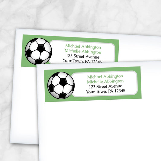 2 Green Soccer Ball Return Address Labels shown on white envelopes on a marble background