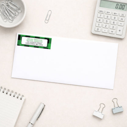 Green and Black Buffalo Plaid Address Label shown on a white envelope with everyday office supplies