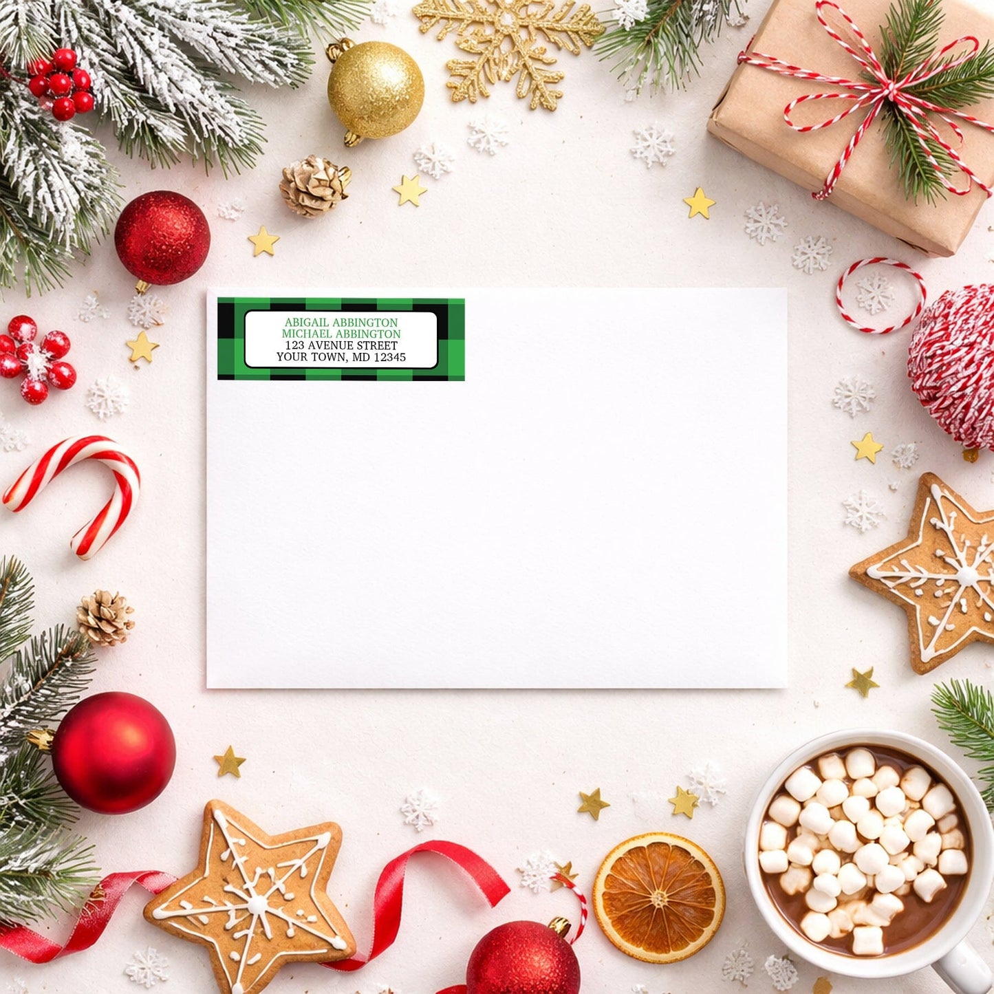 Green and Black Buffalo Plaid Address Label shown on a white envelope with winter Christmas holiday supplies