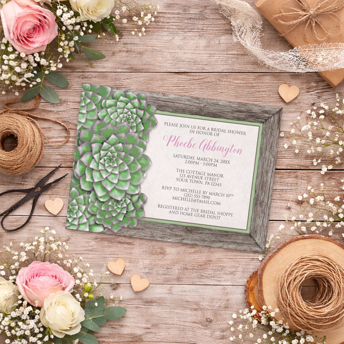 Green and Pink Succulent Wood Bridal Shower Invitation on a wooden surface with flowers and twine.