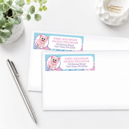 Happy Pig Pink Blue and Purple Plaid Address Labels, shown on white envelopes, on a white surface with a plant and a pen.