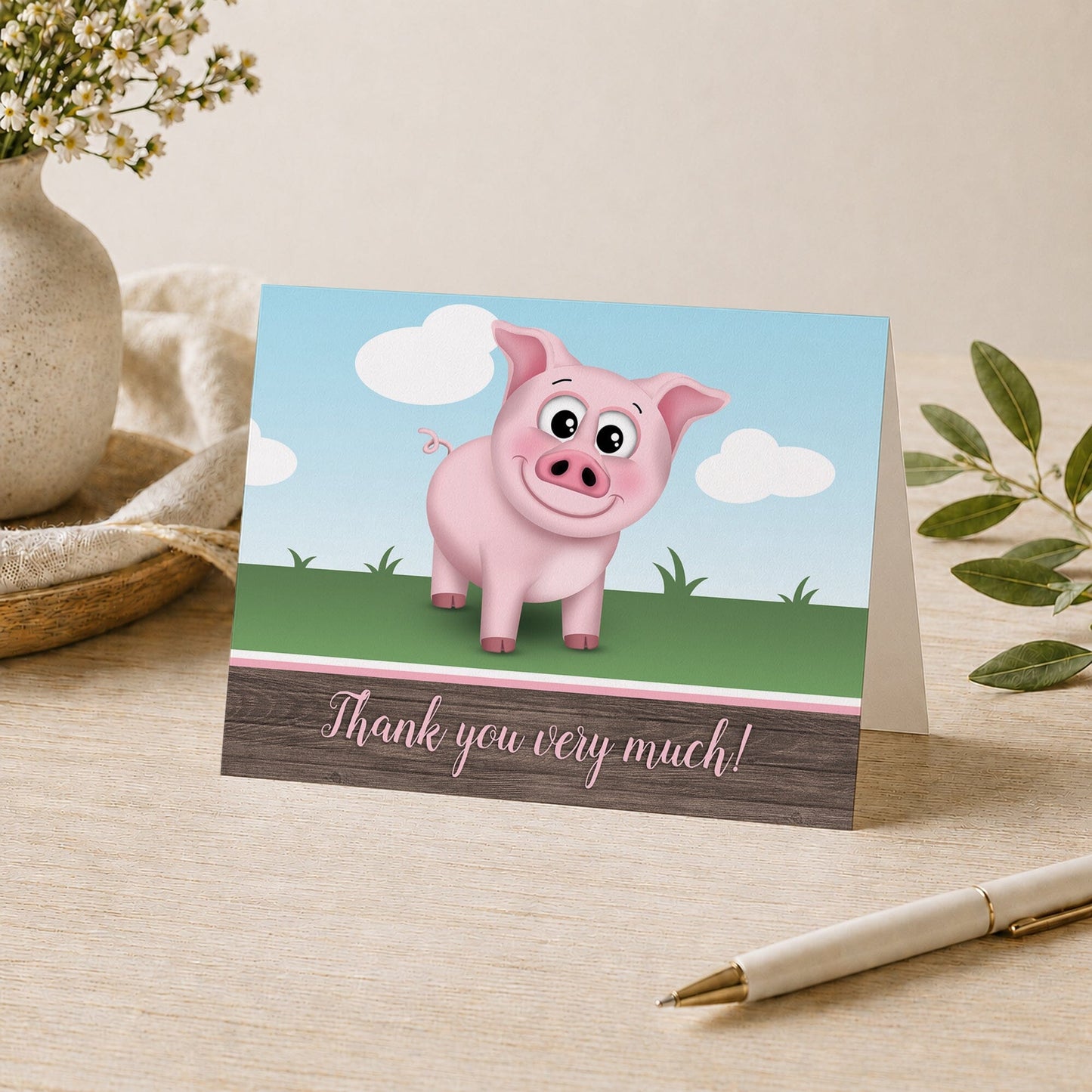 Happy Pink Pig on the Farm Thank You Card shown on a desk with a vase, plants, and a pen.